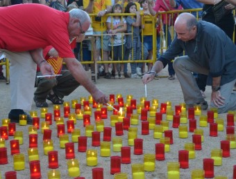 Lluís Llach, a la dreta, en el moment d'encendre les espelmes de l'acte de diumenge a Porqueres. ANC DEL PLA DE L'ESTANY