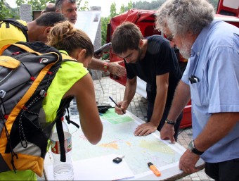 Alguns dels participants en la batuda per localitzar l'avi desaparegut assenyalen en un mapa la zona que han percorregut ACN