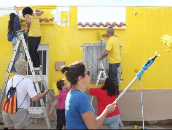 Voluntaris pintant les cases de groc.
 J. FERNÀNDEZ