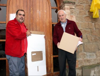 Un repartidor entrega a l'alcalde dels Plans de Sió, Adrià Marquilles (a la dreta), la urna desmuntada i el material necessari per a la votació del proper 9-N ACN