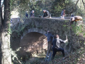 Els voluntaris quan treballaven en el condicionament del pont de la font del Salt Dalmau, de Camós, la setmana passada. MATEU BUTINYÀ