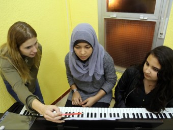 Una mestra voluntària fa classe de piano a la Chaima i l'Avir a l'escola Llibertat. QUIM PUIG