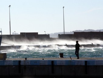 El vent aixeca l'aigua del mar i l'empeny contra l'espigó de Palamós ACN