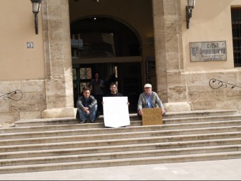 Tres aturats protesten davant la porta de l'Ajuntament de Paterna. ESCORCOLL