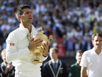 nova Djokovic, amb el trofeu de campió de l'any passat amb Roger Federer al fons REUTERS