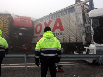 Dos mossos d'esquadra contemplen dos dels camions que s'han vist afectats per un accident múltiple a l'AP-2 a Castelldans, amb les cabines de conducció totalment destrossades ACN