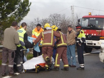 Bombers i sanitaris retirant una persona ferida en un accident de trànsit a la variant de Banyoles de la C-66. R. E