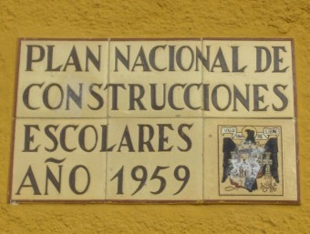 Imatge de la placa amb l'escut franquista absn de ser enretirada. EL PUNT AVUI