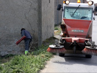 Un operari de l'Ajuntament neteja les restes del cotxe sinistrat, aquest dijous a Bellvís ACN