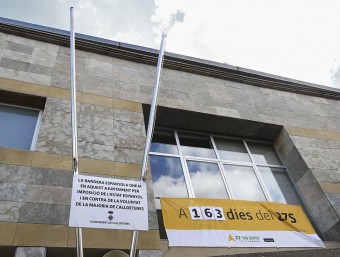 Els pals sense cap bandera acompanyats del cartell que justifica l'acció JORDI PUIG / EL 9 NOU
