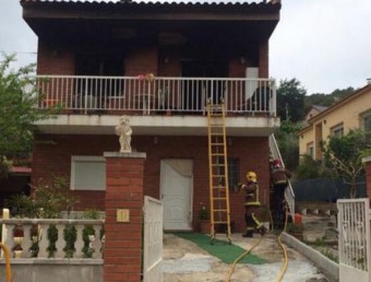 Imatge de la casa on s'ha produït l'incendi, amb els Bombers treballant ACN
