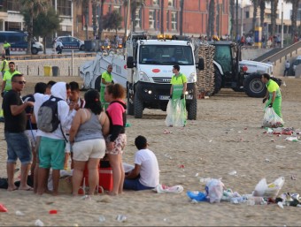 Treballs de neteja amb gent escurant la festa a les platges de Barcelona, l'any passat A.PUIG