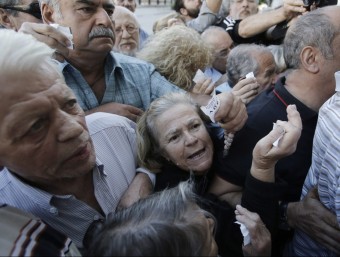 Jubilats grecs lluitant per entrar al banc a treure les seves pagues YANNIS KOLESIDIS / EFE