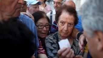 Pensionistes grecs rebent tiquets per ser atesos amb prioritat a l'hora de cobrar les seves pensions YIANNIS KORTOGLOU /REUTERS
