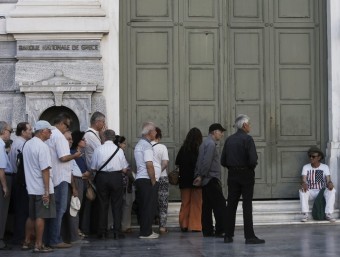 Ciutadans grecs fan cua davant una sucursal del Banc Nacional de Grècia en el centre d'Atenes EFE