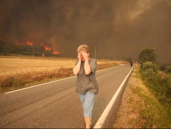 Una dona fugint de les flames que estaven cremant la seva granja el primer dia de l'incendi. LL. SERRAT 