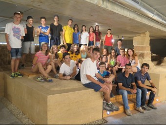 Nois i noies de la Fundació Josep Carol a l'antic temple de Santa Maria, amb l'alcalde d'Alcarràs Miquel Serra ACN