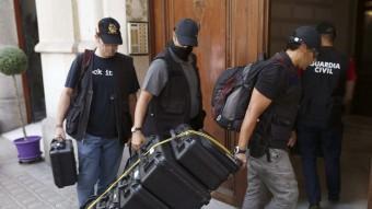 Agents de la Guàrdia Civil i Anticorrupció traslladen maletes per procedir a l'escorcoll de la fundació Catdem EFE