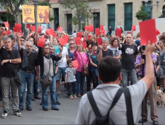 Els assistents a la concentració de protesta, amb una targeta vermella a les mans, ahir a la tarda JUDIT FERNÀNDEZ