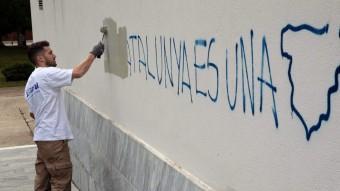 Un operari de la brigada de neteja borra una de les dues pintades que han aparegut al centre cultural Mira-sol de Sant Cugat del Vallès, on ha votat Romeva EFE