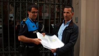 L'alcalde d'Alcarràs, Miquel Serra i el sergent de la policia local del municipi lliurant les signatures ACN