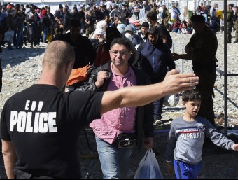 Un grup de refugiats siris reben instruccions d'un policia a la frontera amb Sèrbia.  ARXIU