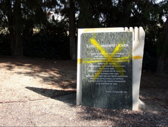 El monòlit amb la placa on s'explica la història del president tacat de groc ACN