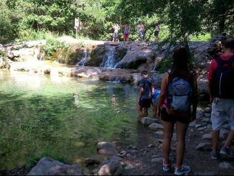 Excursionistes a la presa del Gomarell, a mig camí de Sant Aniol, el mes d'agost d'aquest any. R. E.