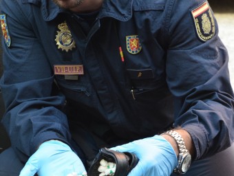 Un policia mostra una part de la droga que van comissar als cinc ocupants del cotxe. POLICÍA NACIONAL