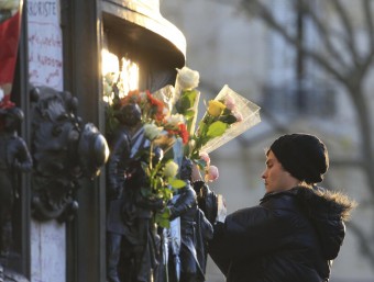 Un noi deixa una flor a la plaça de la República, a París, en homenatge a les víctimes dels atemptats de divendres REUTERS