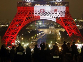 Policies vigilant davant la Torre Eiffel, il·luminada amb els colors de la bandera francesa, ahir reuters
