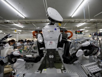 Industrial robots working alongside people in a Japanese factory 
