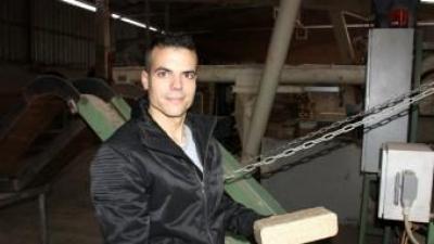El responsable de producte d'Acalora, Ramon Masó, mostrant dues briquetes de serralles de fusta acabades de fabricar ACN