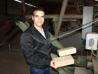El responsable de producte d'Acalora, Ramon Masó, mostrant dues briquetes de serralles de fusta acabades de fabricar ACN