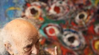 Jaume Muxart, davant del quadre amb un arbre d'ulls que està realitzant al seu taller ANDREU PUIG 