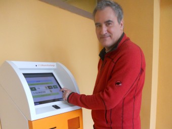 Miquel J.Pavón amb el caixer de bitcoins que hi ha a l'oficina de Lluís Pericot. U.COMAS