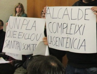 Tres persones del públic mostren pancartes de rebuig al Pla Parcial abans de ser desallotjats del ple G.FREIXA