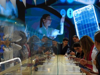 A group of visitors trying out the latest smartphones at this year's Mobile World Congress in Barcelona./  AFP