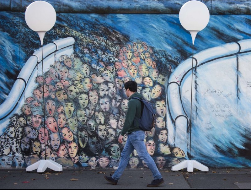 A man passing by the “light border” installation along the remains of the Berlin Wall.  AFP