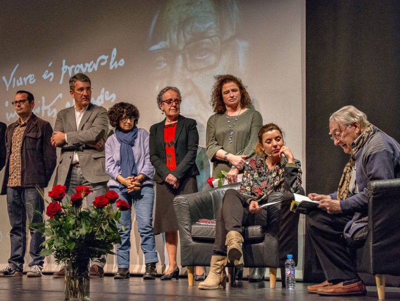 Màrius Sampere , assegut a la dreta de la imatge, llegeix un dels seus poemes davant dels membres del jurat que li ha atorgat el premi singladura per la seva trajectòria. ALBERT GÀMIZ