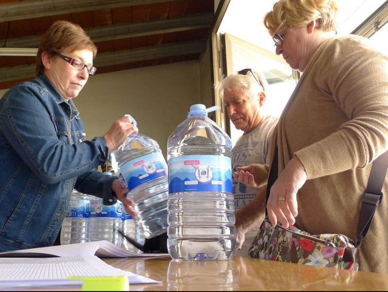 Dues veïnes recullen l'aigua en garrafes que subministra l'Ajuntament. NURI FORNS