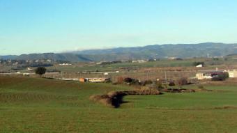 Panoràmica de Sant Fruitós de Bages, amb els terrenys de l'aeròdrom, on ara es fan salts amb paracaigudes, al fons J.G