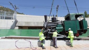 Uns operaris col·loquen la locomotora de vapor a les instal·lacions de Ferrocarrils a Monistrol de Montserrat, ahir FGC