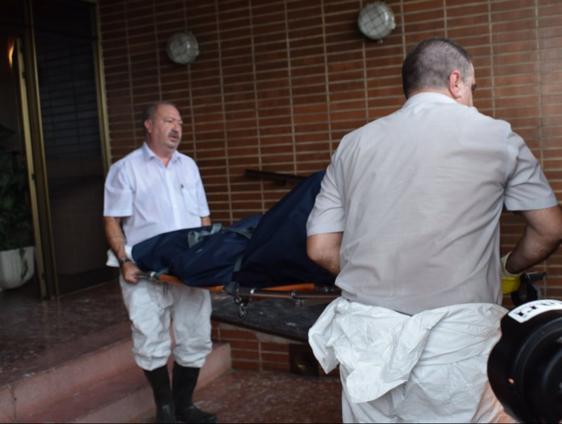 Operaris dels serveis funeraris retiren el cos C. RUIZ