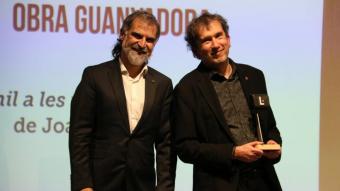 El president d’Òmnium, Jordi Cuixart, amb el guanyador del cinquè Premi Òmnium a la Millor Novel·la de l’Any, Joan Lluís-Lluís, a la llibreria Ona