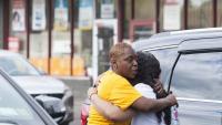 Dues dones s’abracen prop del supermercat on hi ha hagut el tiroteig a Buffalo (Nova York)