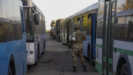 Milicians prorussos vigilen els autobusos preparats per evacuar els combatents de l’acereria de Mariúpol, dimarts a la nit