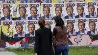 Dues dones passen per davant d’una paret amb cartells del candidat Gustavo Petro, de la coalició Pacte Històric, a Bogotà