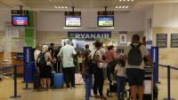 Uns passatgers esperen a ser ateses al taulell de Ryanair a l’aeroport de Girona, ahir al migdia