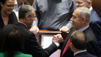 Netanyahu –dreta– estreny satisfet la mà a un diputat del seu partit, el Likud, després de la votació al Parlament per dissoldre el govern